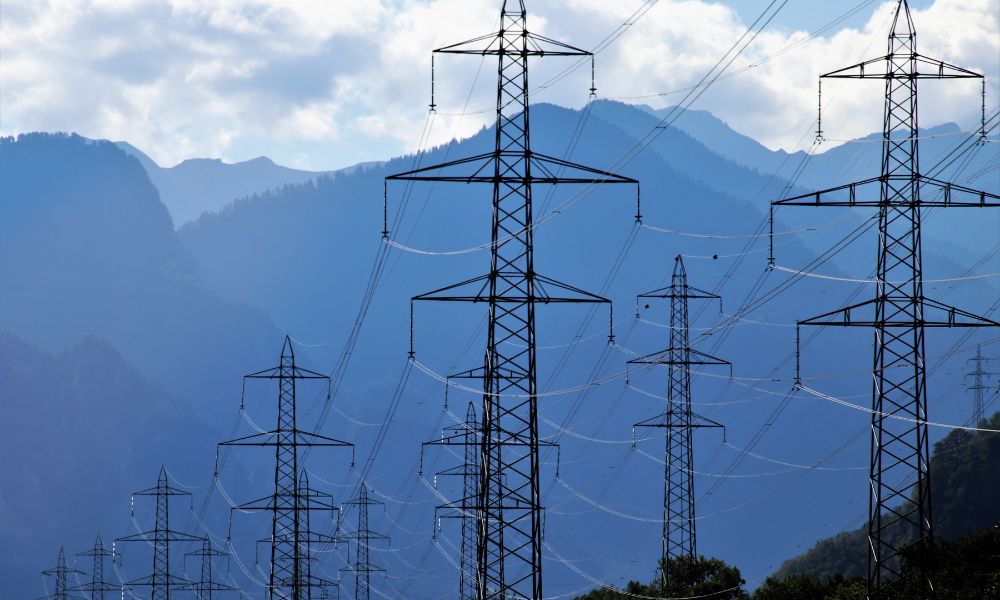 Dağlardaki elektrik direkleri, enerji iletimini sağlayan önemli yapılar olarak görünmektedir.