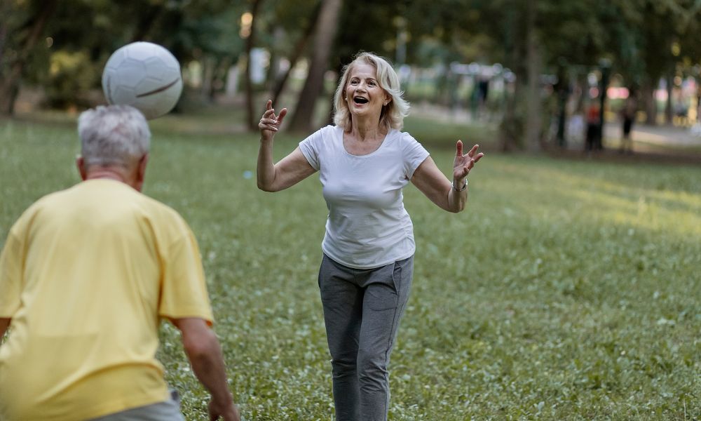 Yaşlı bir adam ve kadının futbol topuyla oynadığı, yaşam kalitesini artıran bir an.