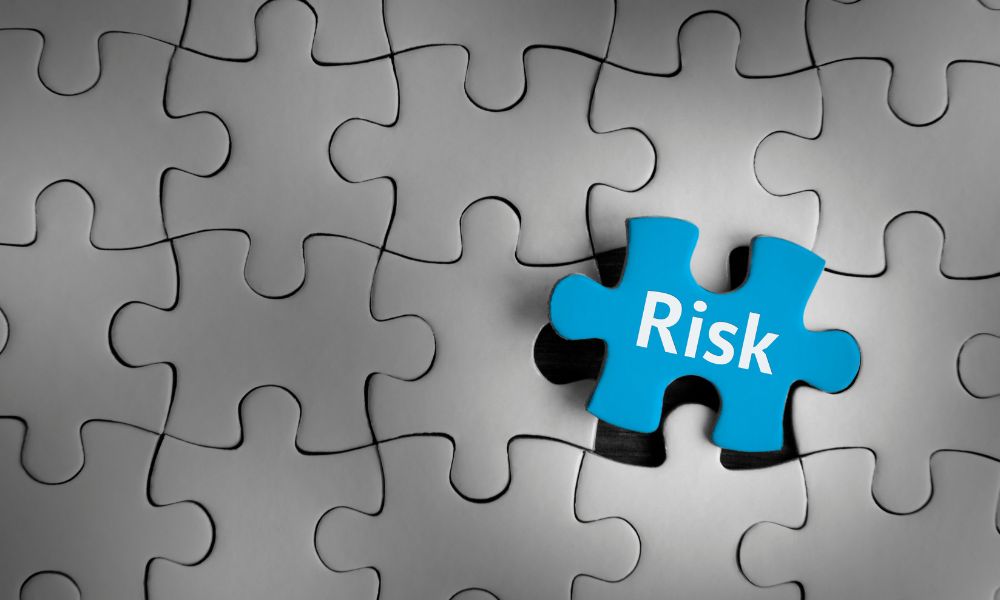 "Risk" etiketli bir mavi parçanın yerine oturduğu siyah beyaz bir bulmaca, risk yönetimini bulmacayı tamamlamanın önemli bir parçası olarak vurguluyor. Risk yönetimi nedir? Bu görsel, belirsizliklerle nasıl başa çıktığımız konusunda düşünmeye davet ederek soruyu zarif bir şekilde ortaya koyuyor.